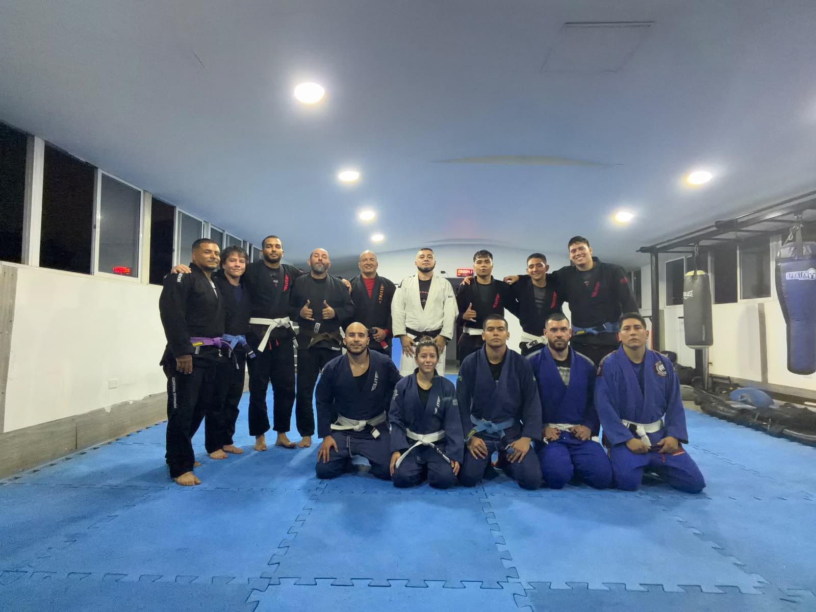 Alumnos con kimono, de pie y arrodillados, en el tatami