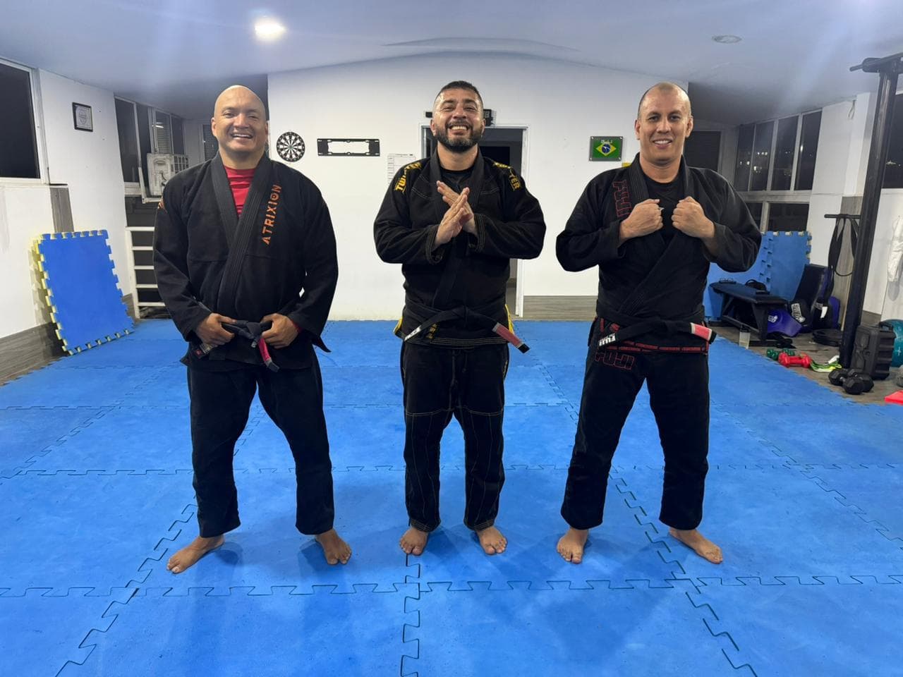 Los profesores Jhon, Fernando y Willmer, cinturones negros de BJJ Time, en el tatami de la academia